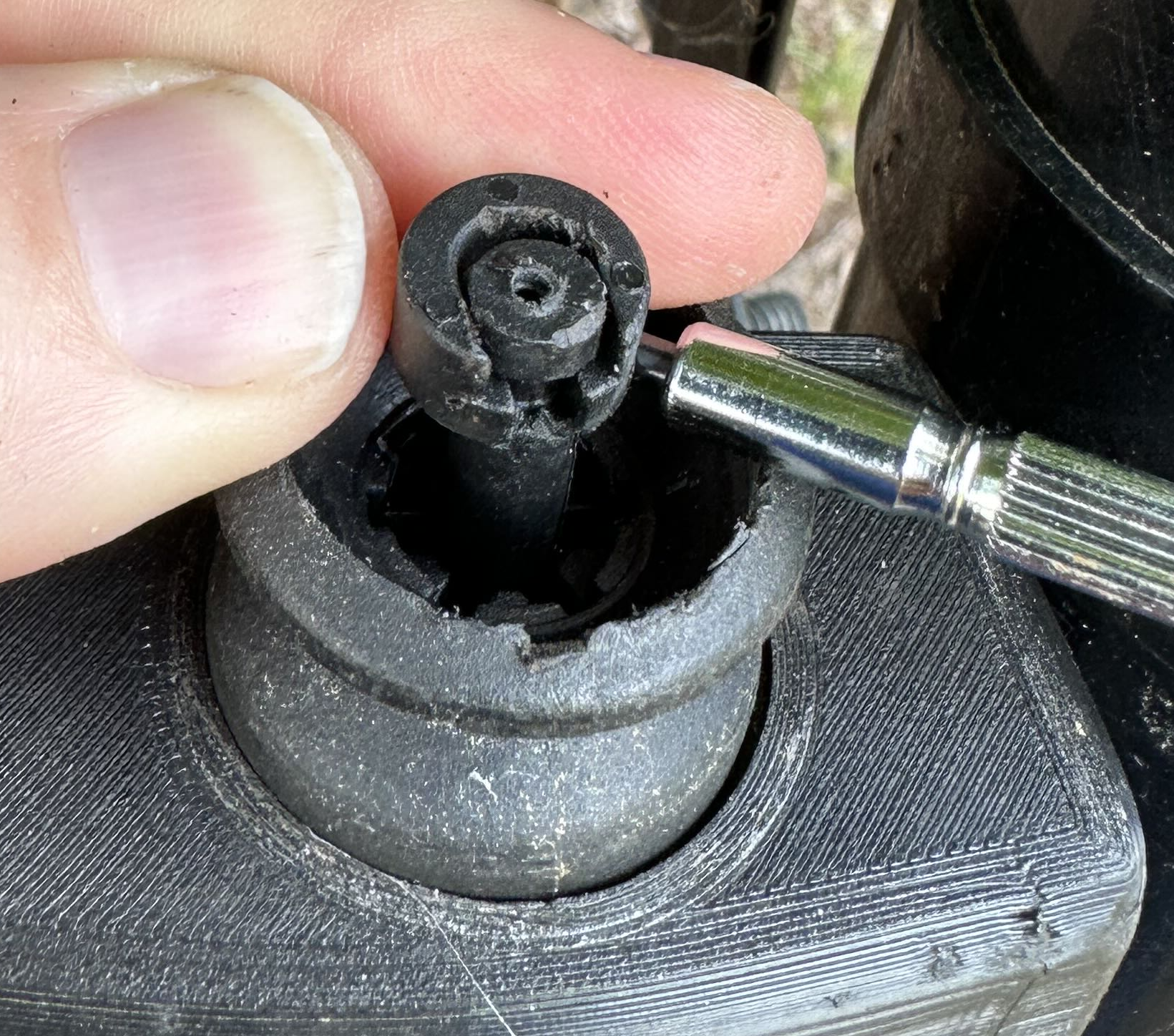 Screwdriver lifting the clip off the shaft